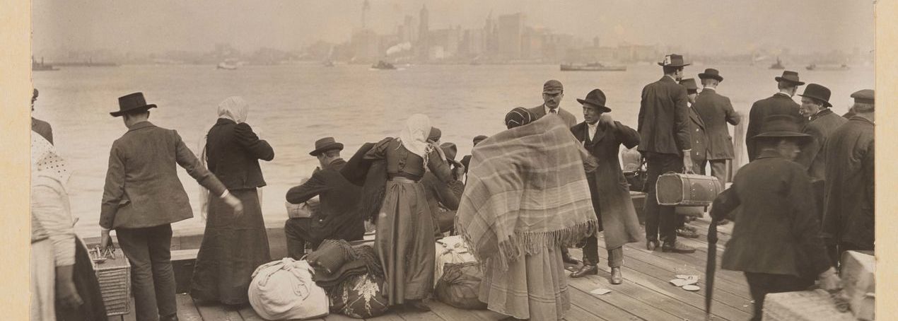 Black and white picture of immigrants on a boat headed to Ellis Island