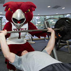 Hooter the Owl spots for a man bench pressing 