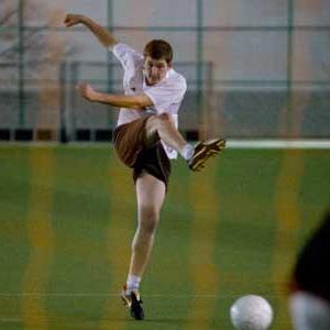 male kicking a soccer ball 