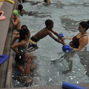 children learning to swim with instructor 