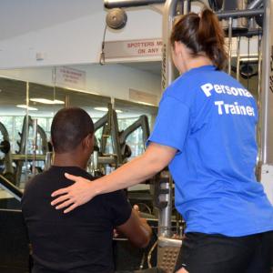 personal trainer helping participant 