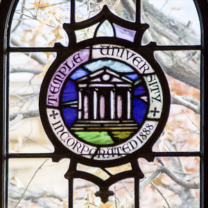 Temple University seal on stained glass.