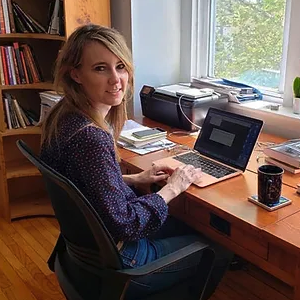 image of Kristina sitting at a desk typing at a computer 