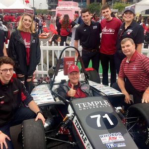 students and faculty with race car