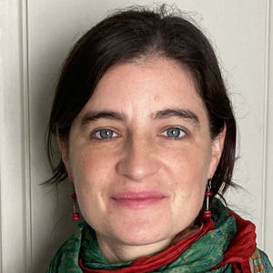Woman wearing a colorful scarf against a white background.