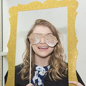 Graduate photographed in a glitter frame with glitter glasses