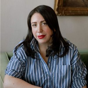 image of Hilary sitting wearing a blue and white striped shirt