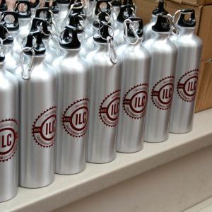 stainless steel water bottles that say inclusive leadership conference on them in red. 