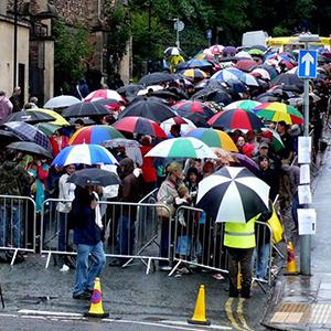 People with umbrellas stand in line 