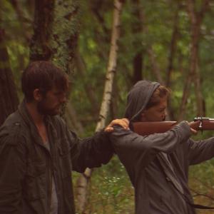 Two men with shotgun in forest
