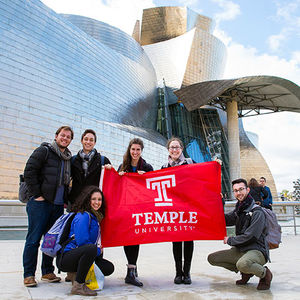 Students standing in Spain with TU flag