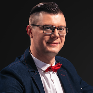 image of Dr.Maksym Yakovlyev wearing glasses, in a blue suit, white dress shit and red bowtie