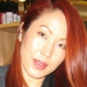 image of Junyoung with red hair wearing a grey shirt and smiling at the camera 
