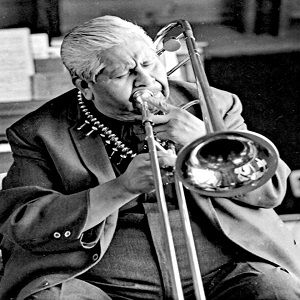 black and white image of a jazz musician in a suit playing the trombone
