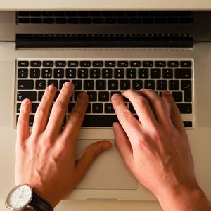 Photo of hands typing on a laptop