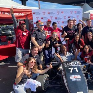 Homecoming attendees with Temple Formula Race car
