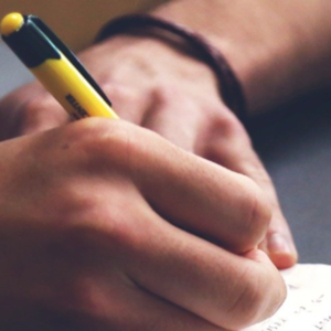 Closeup on hands in the act of writing