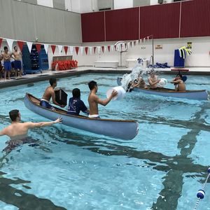 Two canoes throw buckets of water at each other in Pearson and McGonigle Halls Pool 31