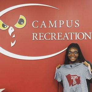 The Campus Rec Flag T-Shirt is being held up by a student staff worker.