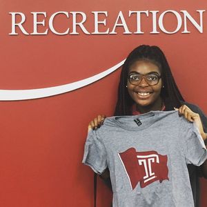 A student staff member holding up one of the Campus Rec Flag T-Shirts.