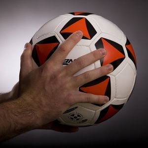 Hands holding a soccer ball.