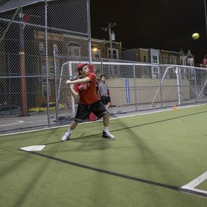 A batter preparing to swing at an incoming pitch.