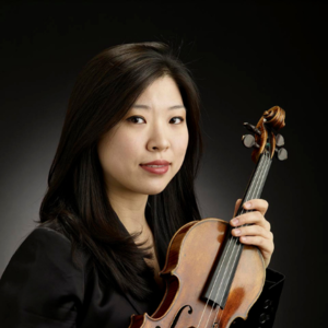 headshot of a woman with long black hair and a black jacket holding a violin