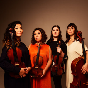 four women in formal attire holding string instruments