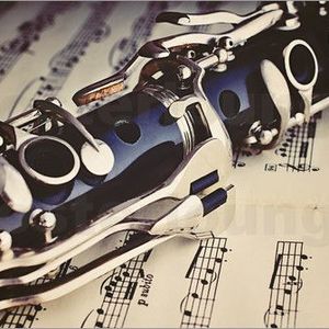 close-up of a clarinet lying atop sheet music
