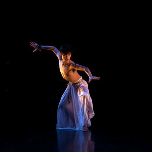 dancer onstage in billowy white pants