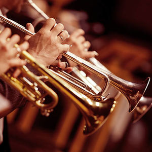 row of musicians hands holding trumpets