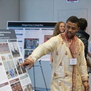 student presents a poster at Global Temple 2014